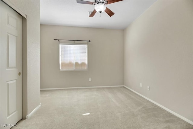 carpeted spare room featuring ceiling fan