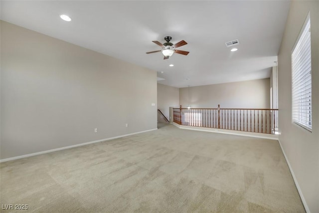 carpeted spare room with ceiling fan