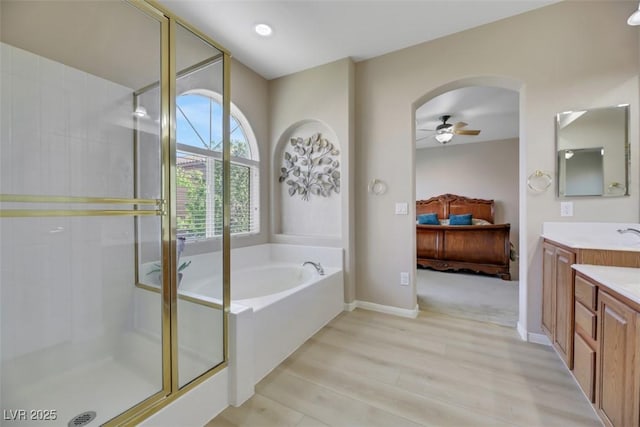 bathroom with hardwood / wood-style floors, vanity, ceiling fan, and independent shower and bath