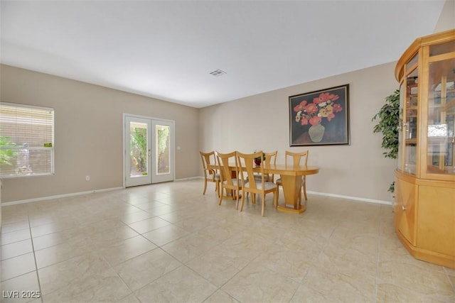 dining room with french doors and light tile patterned flooring