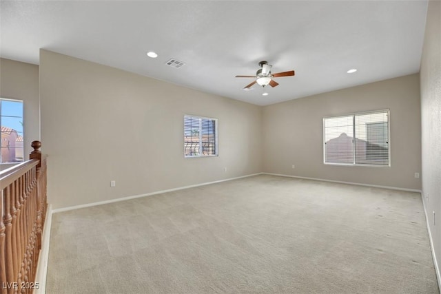 spare room with ceiling fan and light colored carpet