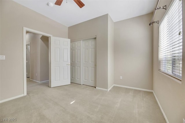 unfurnished bedroom with ceiling fan, a closet, and light colored carpet