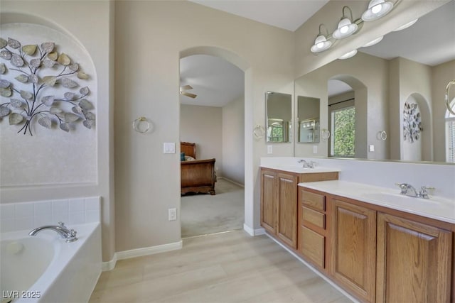 bathroom featuring vanity, a bathtub, and ceiling fan