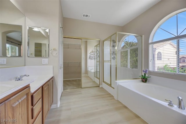 bathroom with shower with separate bathtub, vanity, and hardwood / wood-style flooring