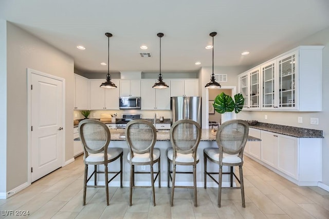 kitchen featuring white cabinetry, a center island with sink, and appliances with stainless steel finishes