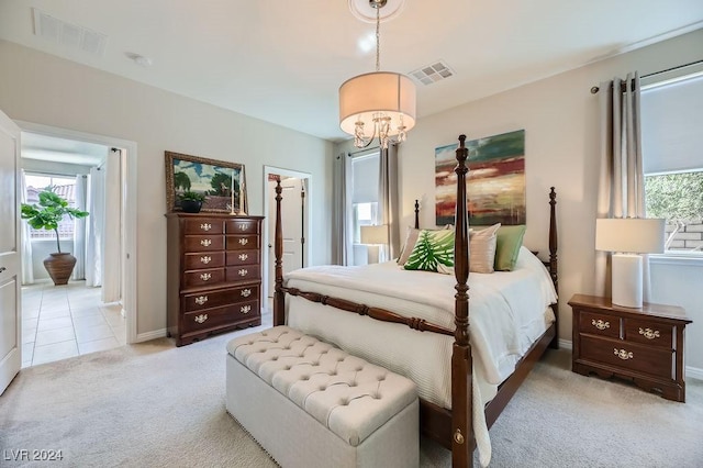 bedroom with a notable chandelier and light colored carpet