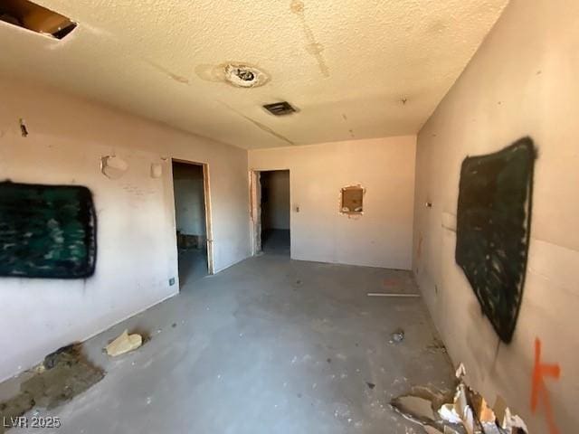 spare room featuring concrete flooring and a textured ceiling