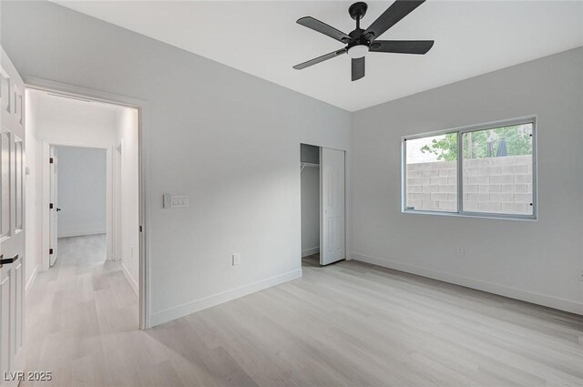 unfurnished bedroom featuring ceiling fan, light wood-type flooring, and a closet