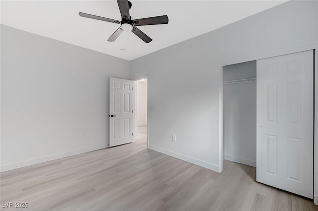 unfurnished bedroom featuring ceiling fan, a closet, and light wood-type flooring