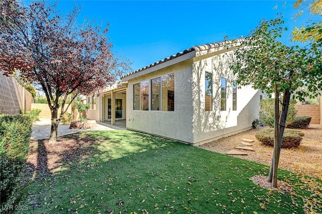 view of side of home with a yard and a patio