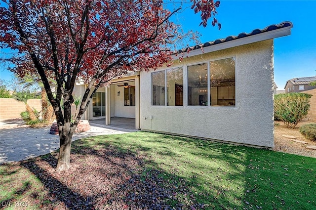 back of house with a lawn and a patio