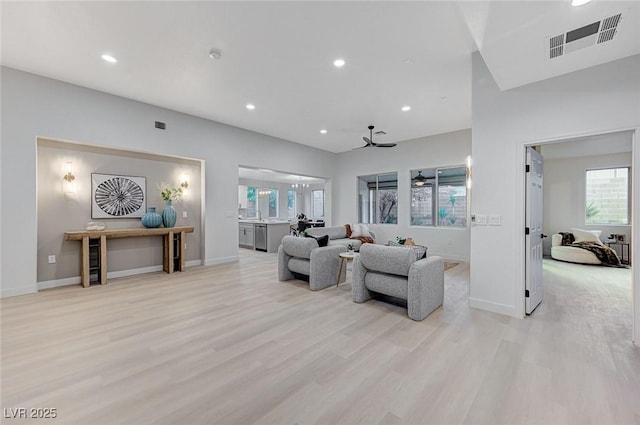 living room with ceiling fan and light hardwood / wood-style flooring