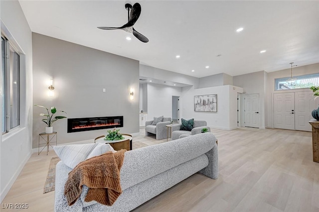 living room featuring ceiling fan and light hardwood / wood-style floors