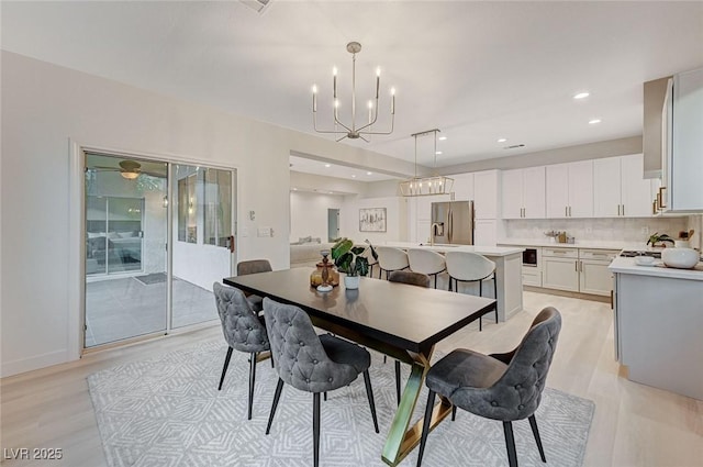 dining space featuring light hardwood / wood-style flooring and an inviting chandelier