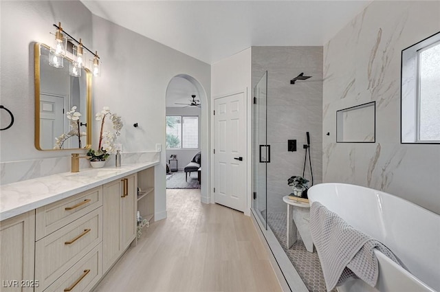 bathroom featuring vanity, hardwood / wood-style flooring, separate shower and tub, and ceiling fan