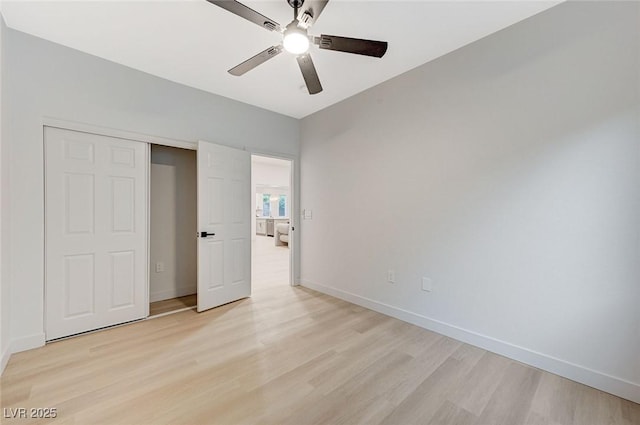 unfurnished bedroom featuring a closet, light hardwood / wood-style flooring, and ceiling fan