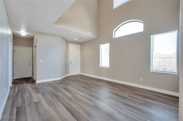 interior space with a towering ceiling and light wood-type flooring