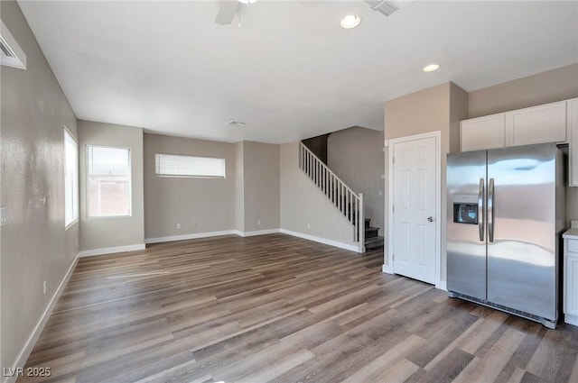 unfurnished living room with ceiling fan and light wood-type flooring