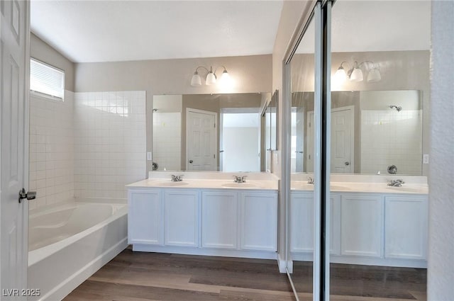 bathroom with hardwood / wood-style flooring, vanity, and plus walk in shower