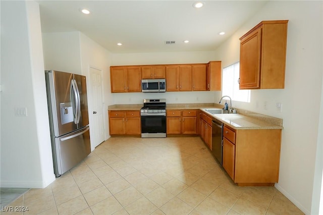 kitchen with appliances with stainless steel finishes, light tile patterned floors, and sink