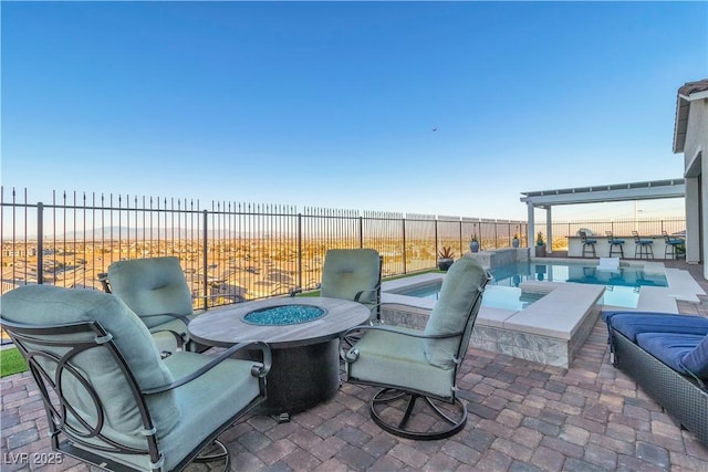 view of patio featuring a beach view, a swimming pool with hot tub, a water view, and an outdoor fire pit