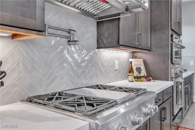 kitchen with premium range hood, dark brown cabinetry, tasteful backsplash, and range