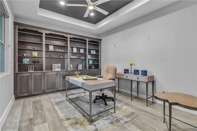 office featuring a raised ceiling and ceiling fan