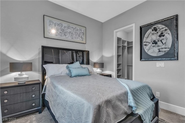 carpeted bedroom with a walk in closet and a closet