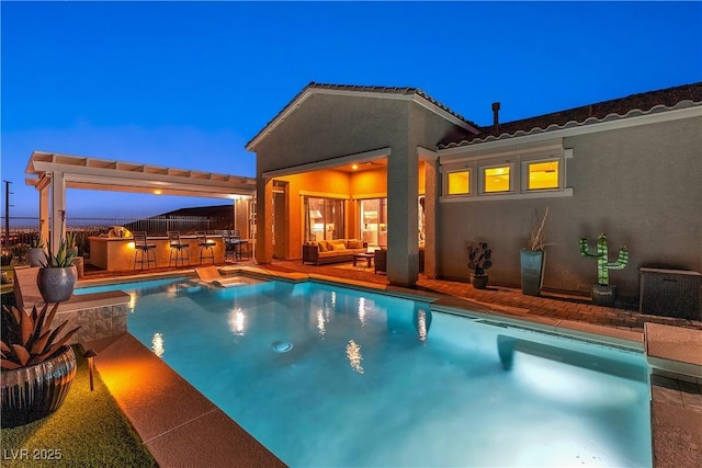 pool at dusk featuring area for grilling, a patio area, and a bar