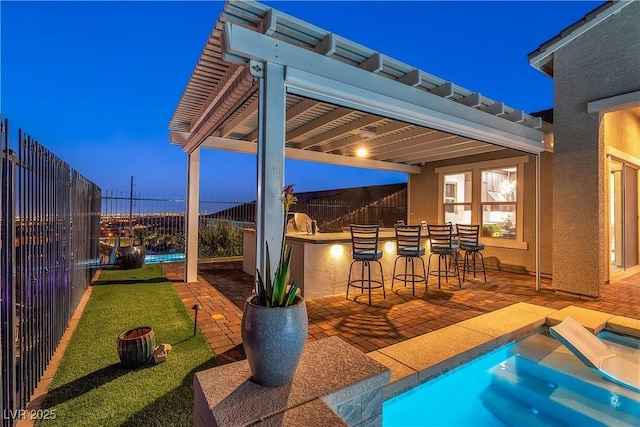 pool at dusk featuring an in ground hot tub, a bar, and a patio area