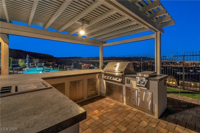 patio terrace at dusk with a pergola, grilling area, and a community pool