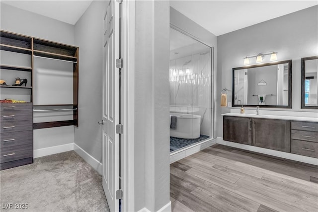 bathroom with hardwood / wood-style floors, vanity, and independent shower and bath