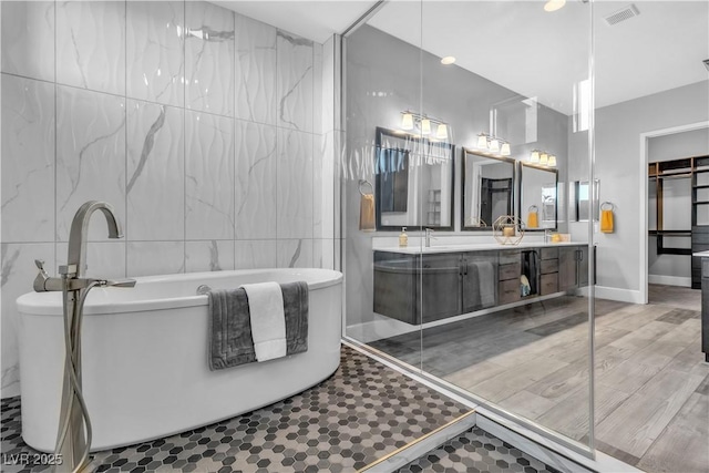 bathroom featuring tile patterned flooring, vanity, and tile walls