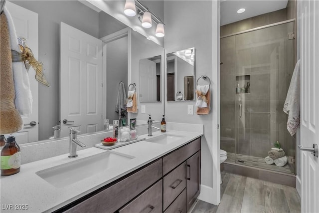 bathroom with walk in shower, vanity, and toilet