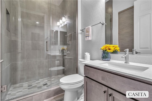 bathroom with walk in shower, vanity, and toilet