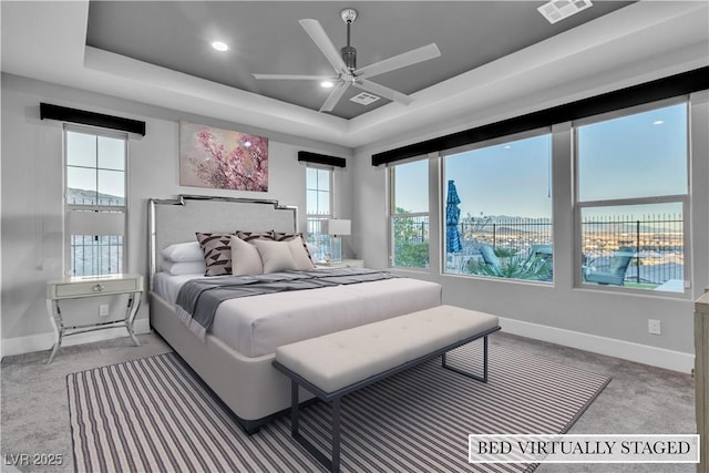 bedroom featuring carpet, ceiling fan, and a raised ceiling