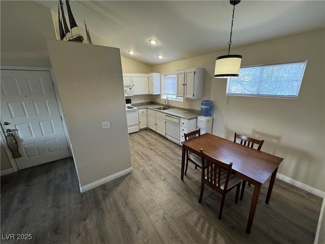 kitchen with white appliances, white cabinets, sink, hardwood / wood-style flooring, and decorative light fixtures