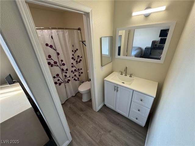 bathroom with hardwood / wood-style floors, vanity, and toilet