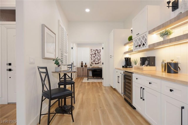 kitchen featuring white cabinetry, beverage cooler, and light wood-type flooring