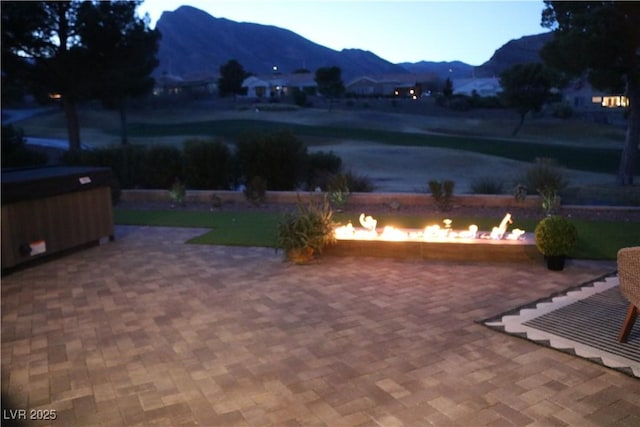 view of patio with a mountain view and an outdoor fire pit