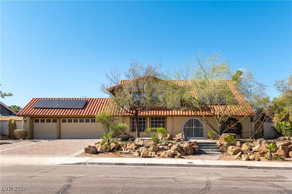 view of front of property with a garage and solar panels