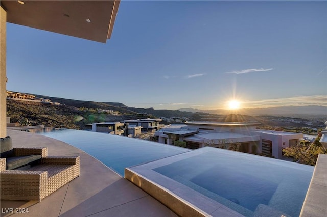 patio terrace at dusk featuring a mountain view