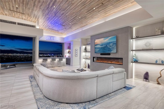 living room with a tray ceiling and wooden ceiling