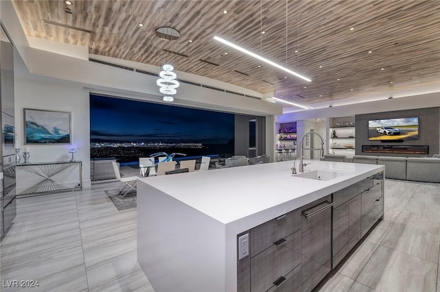 kitchen featuring wooden ceiling, oven, a spacious island, and sink