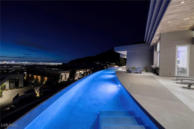 pool at twilight featuring a patio