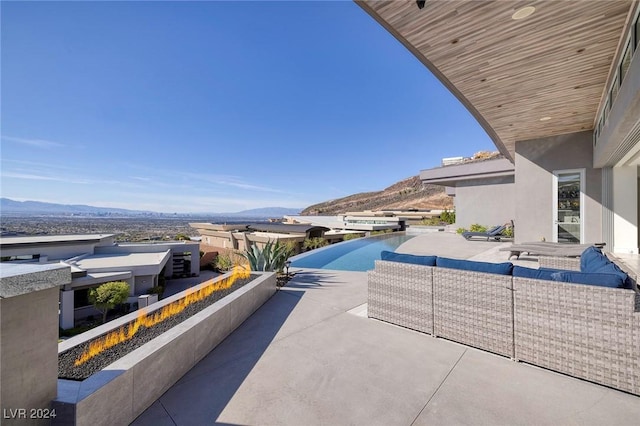 view of patio featuring a mountain view and an outdoor living space with a fire pit