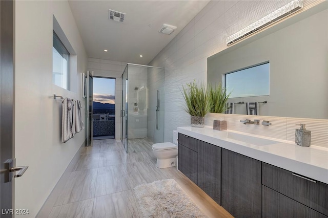 bathroom with vanity, toilet, and an enclosed shower