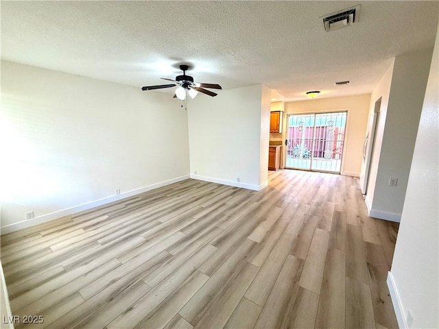 unfurnished living room featuring ceiling fan, light hardwood / wood-style floors, and a textured ceiling