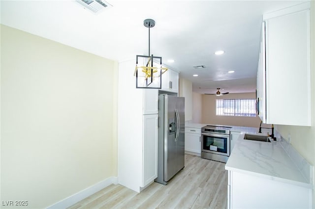 kitchen featuring decorative light fixtures, light stone countertops, white cabinetry, and stainless steel appliances