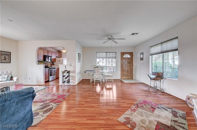 living room featuring light wood-type flooring and ceiling fan